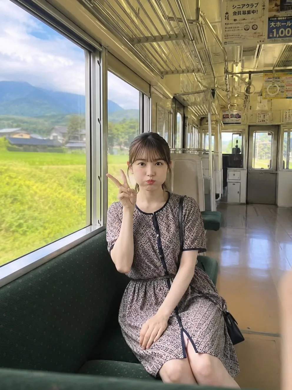 สาวญี่ปุ่นแก้มป่องชูสองนิ้วในรถรางชนบท 1