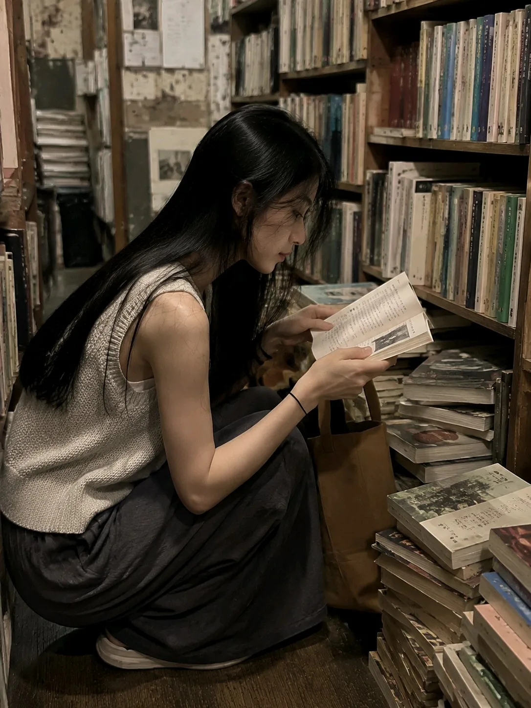 หญิงสาวอ่านหนังสือในร้านหนังสือเก่า: ภาพถ่ายมือถือ 1
