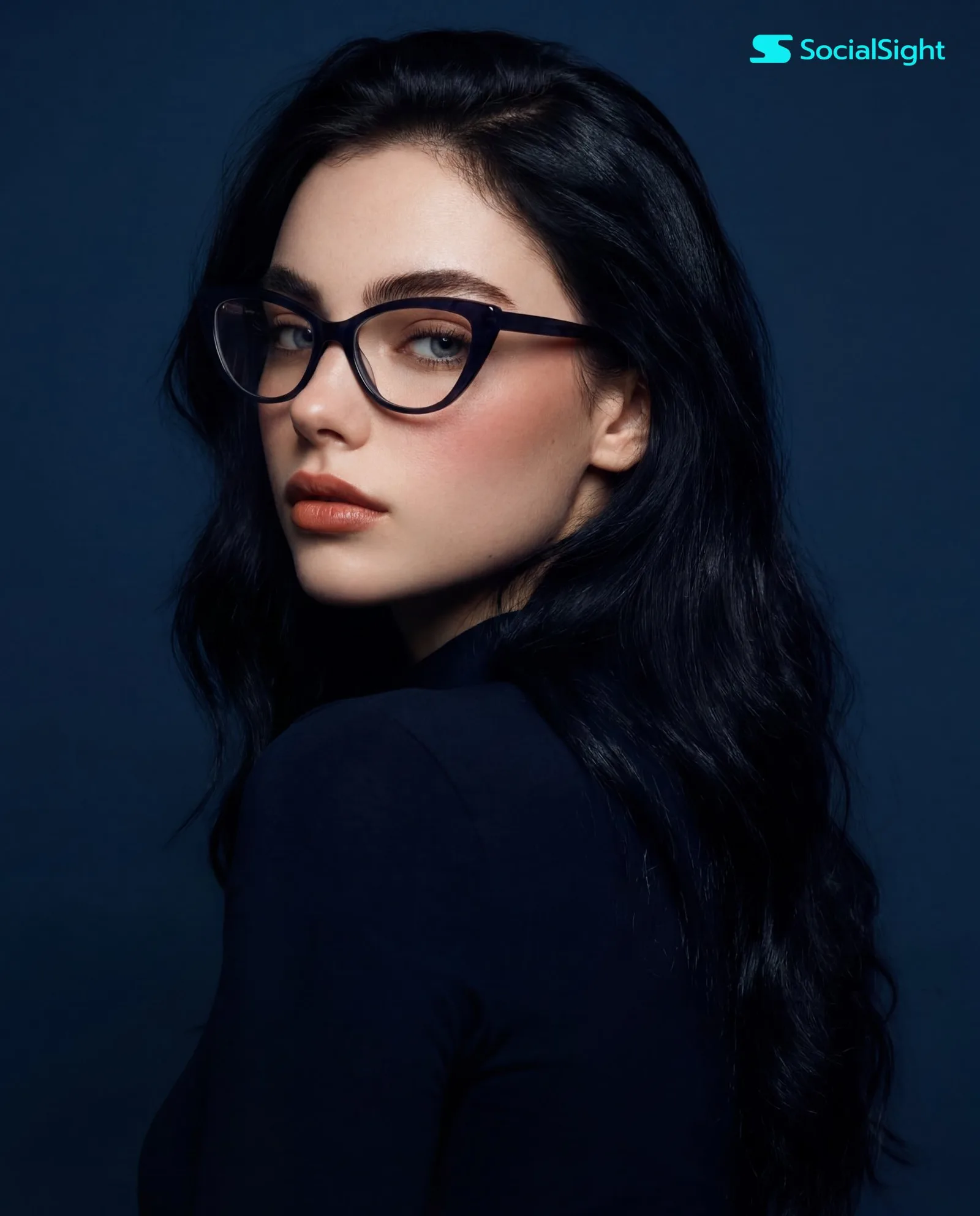 สาวแว่นมั่นใจ หันข้างมองกล้อง พื้นหลังสีน้ำเงิน 1
